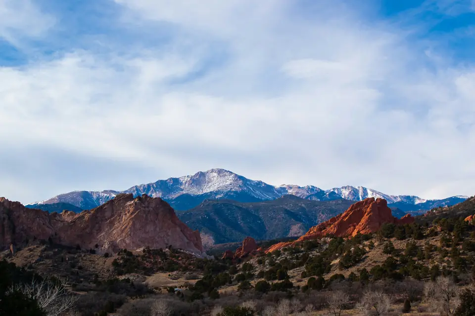 Red sandstone formations of Garden of the Gods with Pikes Peak behind them